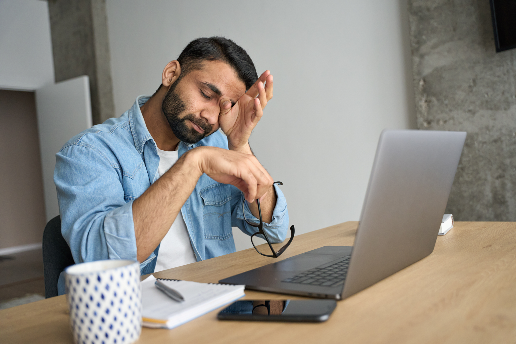 Man with chronic stress while using his laptop